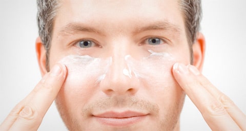 Hombre aplicando crema facial