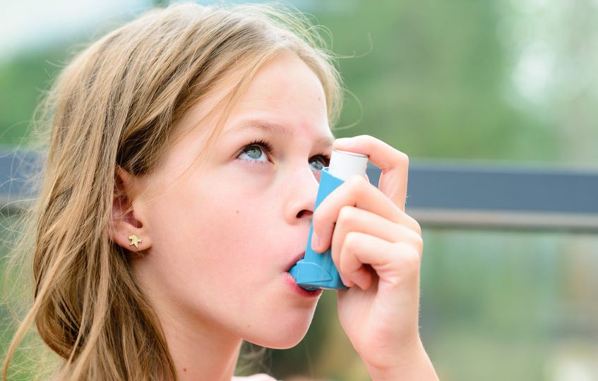 niña con su inhalador de asma