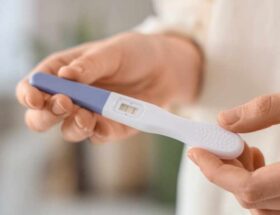 Prueba de embarazo en mano, relacionada con el inicio del control prenatal y revisión de ITS